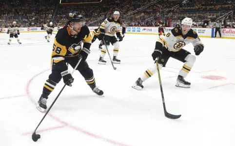 Pittsburgh Penguins defenseman Kris Letang (58) skates with the puck against Boston Bruins defenseman Mason Lohrei (6) during the third period at PPG Paints Arena.
