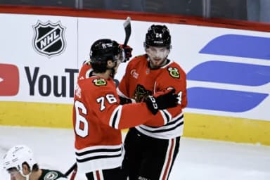 Chicago Blackhawks defenseman Bowen Byram (24) celebrates with left wing Nick Lardis (76) after he scored the game winning goal during the overtime period against the Minnesota Wild at the United Center.